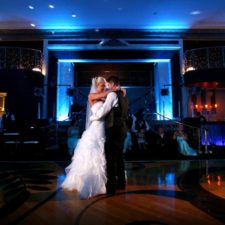 Image of bride and groom sharing ballroom first dance in the wedding venue lighting with blue