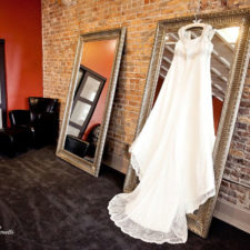 Image of brides wedding dress hanging in the bridal suite before wedding reception